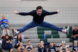 dad doing a cheer toe touch for fundraiser