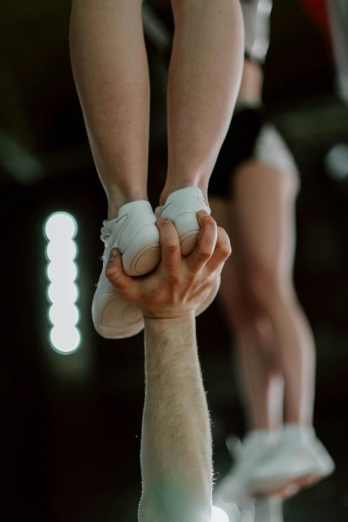 Zoomed in picture of Man holding cheerleader up with one hand